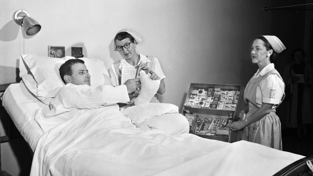 Man buying cigarettes from his hospital bed in the 1950s